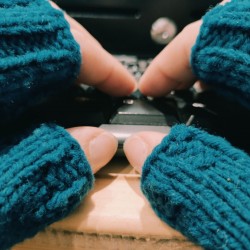 Doigts avec mitaines bleu métis en laine mérinos sur clavier